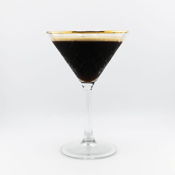 A Dodo Bird Kitchen and Cocktails espresso martini in a gold-rimmed, etched glass.