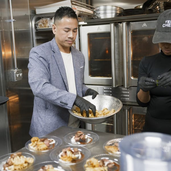 Chef plating Dodo Bird Kitchen and Cocktails' bar-and-grill dishes in a busy kitchen.